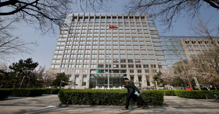 FILE PHOTO: Man walks past the headquarters of Agricultural Bank of China in Beijing