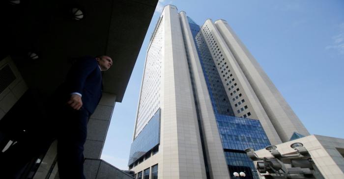 FILE PHOTO: Man walks near headquarters of Gazprom during annual general meeting of company's