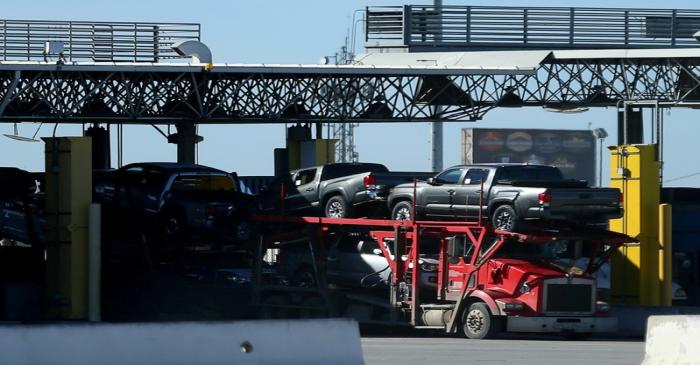 FILE PHOTO: New trucks are transported across the the border into the United States from Mexico