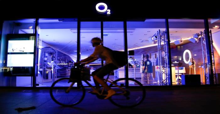 A cyclist passes the front of a O2 Deutschland shop in Berlin