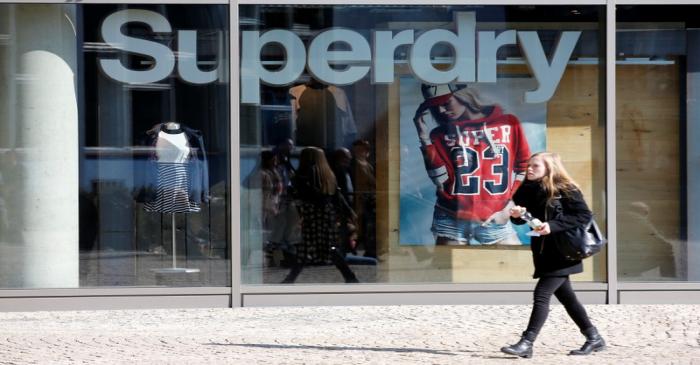 FILE PHOTO: A woman walks past a Superdry fashion store in Berlin