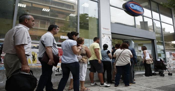 People wait outside a Greek Manpower Employment Organisation (OAED) office in a suburb of