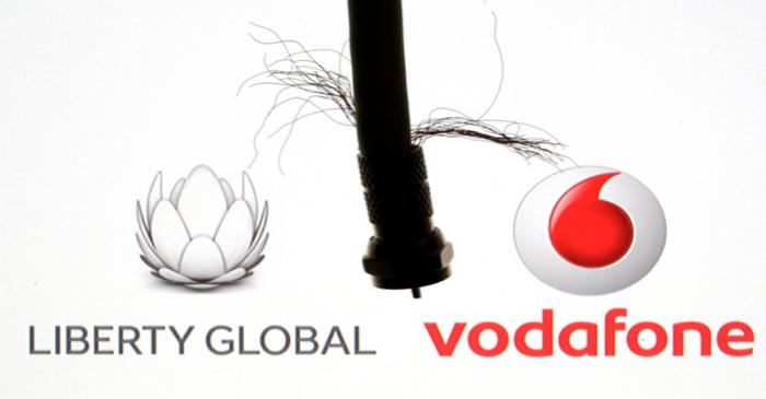 Coaxial TV Cable is seen in front of Vodafone and Liberty Global logos in this illustration