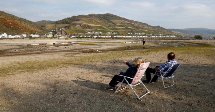 FILE PHOTO: A couple sit on their camping chairs amid the river bed of the dried out Rhine near