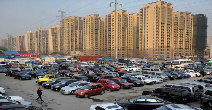 FILE PHOTO: Car dealers and customers walk at a second-hand car market in Hefei