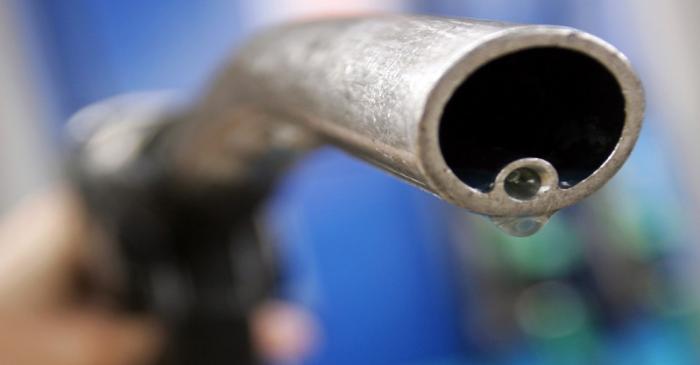 A motorist holds a fuel pump at a Gulf petrol station in London