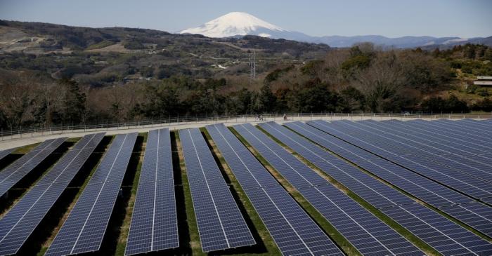 FILE PHOTO: Solar panels are seen at a solar power facility as snow covered Mount Fuji is