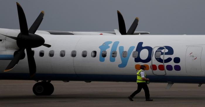 FILE PHOTO: An airport worker examines a flybe aircraft before it takes off from Liverpool John