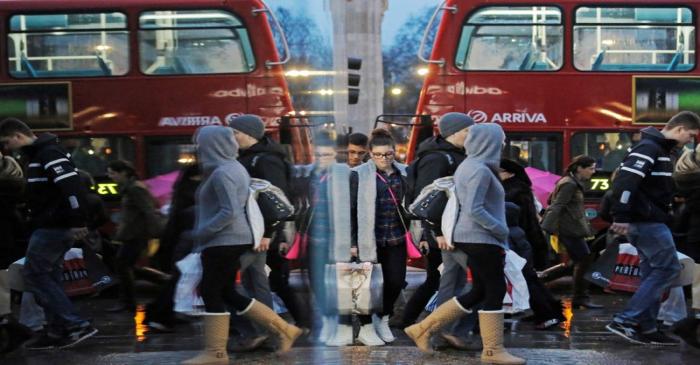 FILE PHOTO:  Shoppers are reflected in a shop window as they walk along Oxford Street on the