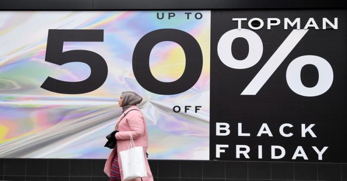 Shoppers walk past Black Friday signage on Oxford Street in London