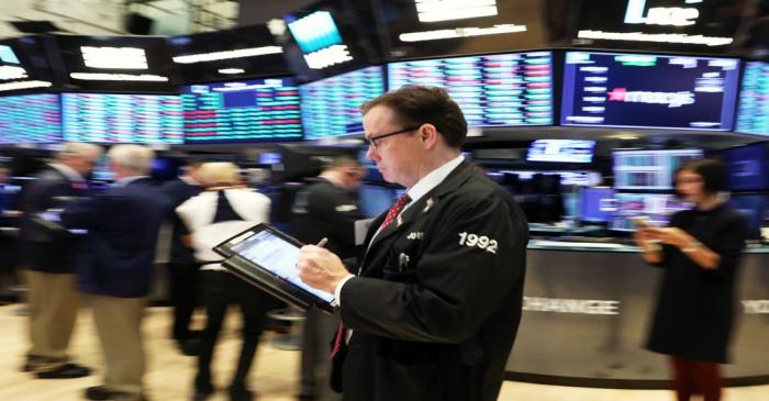 FILE PHOTO: A trader works on the floor at the New York Stock Exchange (NYSE) in New York