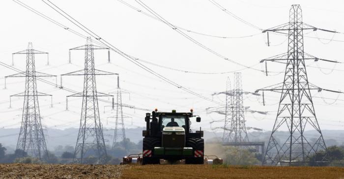 FILE PHOTO: A farmer works in a field surrounded by electricity pylons in Ratcliffe-on-Soar