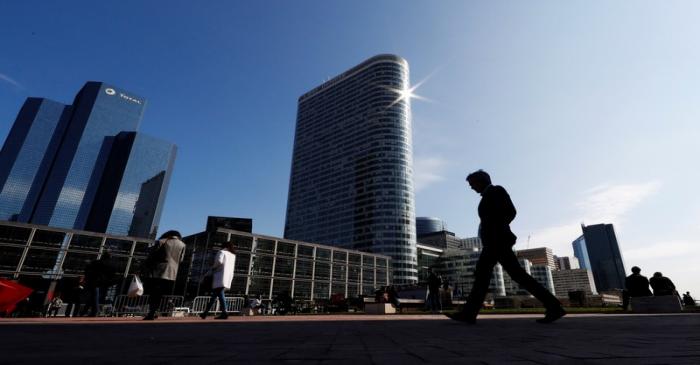 People walk on the esplanade of La Defense in the financial and business district of La