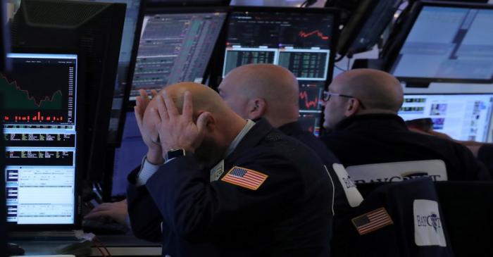 FILE PHOTO: FILE PHOTO: A trader works at his post on the floor of the NYSE in New York