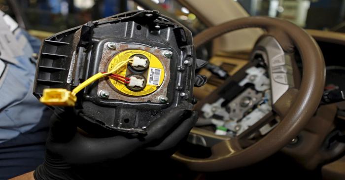 File photo of a technician holding a recalled Takata airbag inflator in Miami