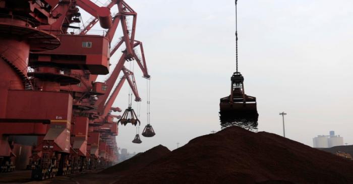 FILE PHOTO: Cranes unload iron ore from a ship at a port in Rizhao