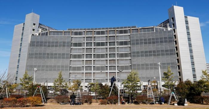 Media crews are seen on step ladders in front of the Tokyo Detention Center, where Nissan's