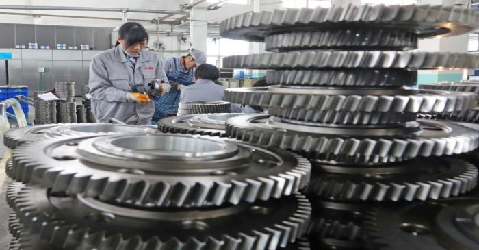 Workers inspect engine gears at a company under Dongbei Special Steel Group in Yantai