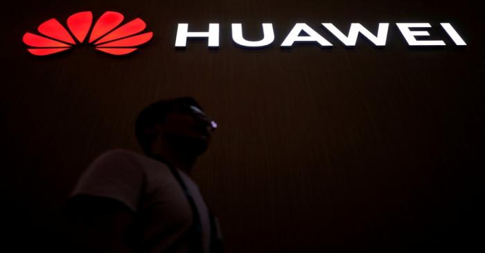 FILE PHOTO: A man walks past a sign board of Huawei at CES (Consumer Electronics Show) Asia