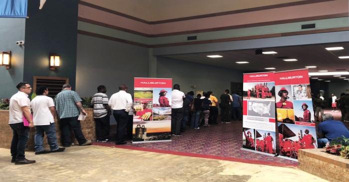 Job seekers line up at a job fair of an oil services giant Halliburton at the MCM Grande