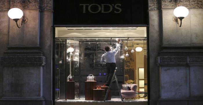 An employee cleans a shop display of a Tod's boutique store at the Galleria Vittorio Emanuele