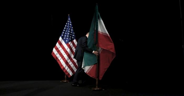 FILE PHOTO: A staff member removes the Iranian flag from the stage after a group picture with