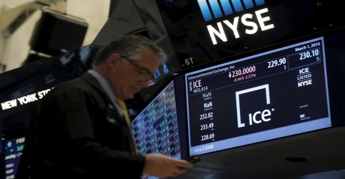 A trader passes by a screen that displays the trading info for Intercontinental Exchange Inc.