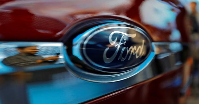 FILE PHOTO: A visitor is reflected as he takes pictures of a new Ford Aspire car during its