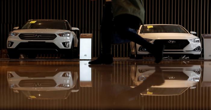 A person walks past Hyundai vehicles in Shanghai