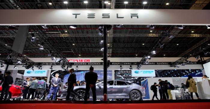 People visit a Tesla booth during the media day for the Shanghai auto show in Shanghai