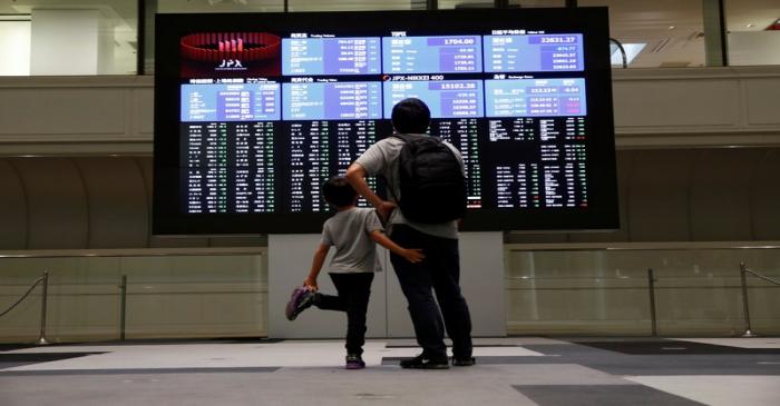 Visitors look at a stock quotation board at Tokyo Stock Exchange in Tokyo