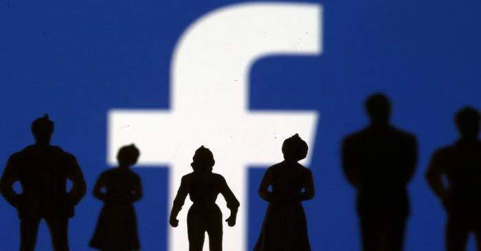 Small toy figures are seen in front of Facebook logo in this illustration picture