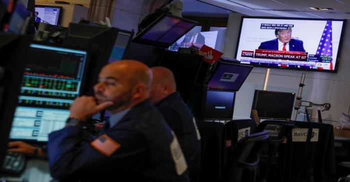 Monitors displaying a media conference with U.S. President Donald Trump at the G7 summit are