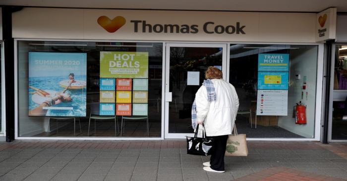 FILE PHOTO: A woman stands outside a closed Thomas Cook travel agents store near Manchester,