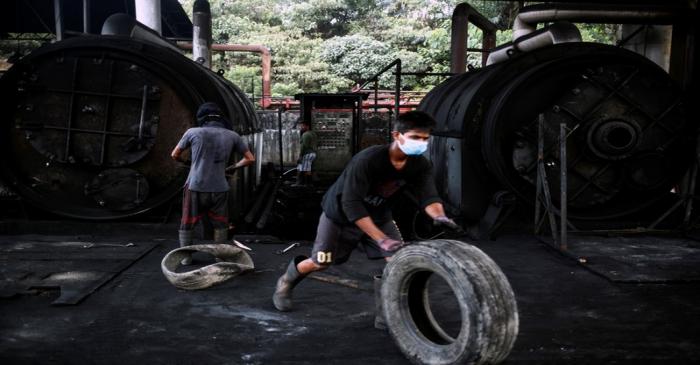 Workers operate furnaces at a tyre pyrolysis plant in Kulai