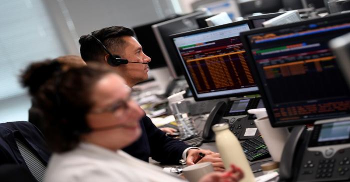 Traders are seen at work at Northern Trust offices in London