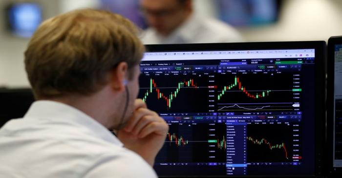 A financial trader works at their desk at CMC Markets in the City of London