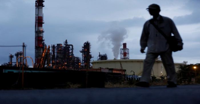 FILE PHOTO: A man walks past a factory at the Keihin industrial zone in Kawasaki