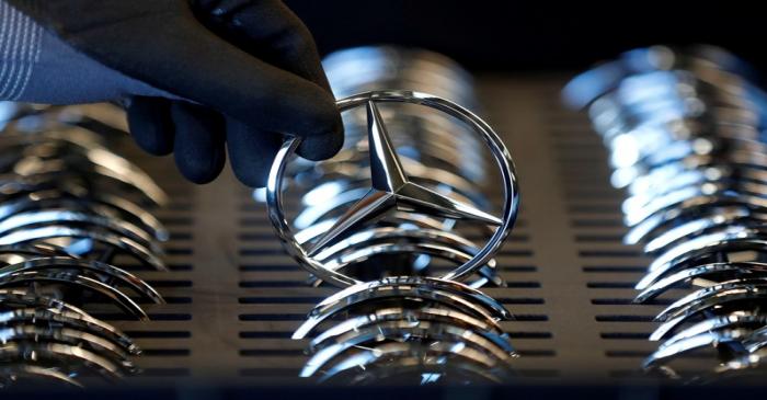 FILE PHOTO: An employee of German car manufacturer Mercedes Benz prepares the company's logo