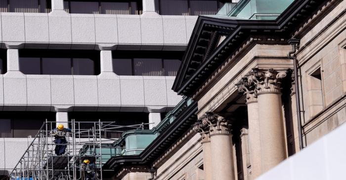 Men work on the outside of the Bank of Japan building in Tokyo