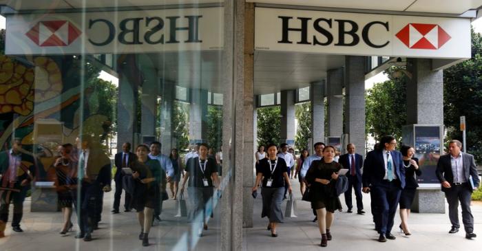 FILE PHOTO: People walk past a HSBC signage in Singapore