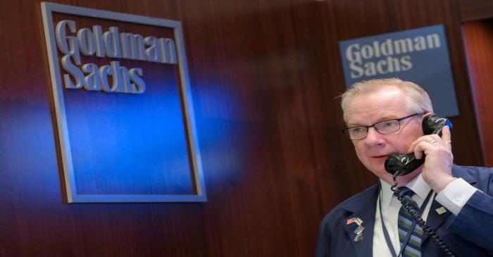 FILE PHOTO: A trader works inside the Goldman Sachs booth on the floor of the  NYSE in New York