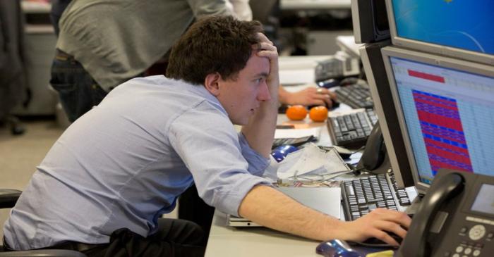 FILE PHOTO: A trader looks at his screen on the IG Group trading floor in London