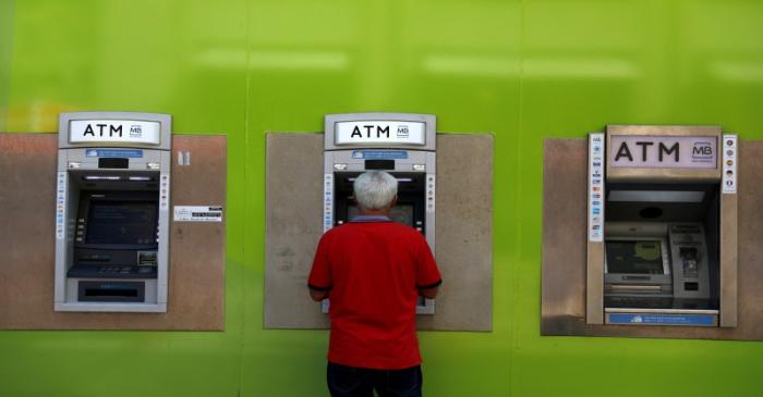 FILE PHOTO: A man uses an ATM at a Novo Banco branch in downtown Lisbon