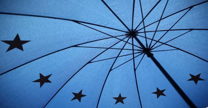 An umbrella with the pattern of the EU flag is seen outside the Houses of Parliament in London