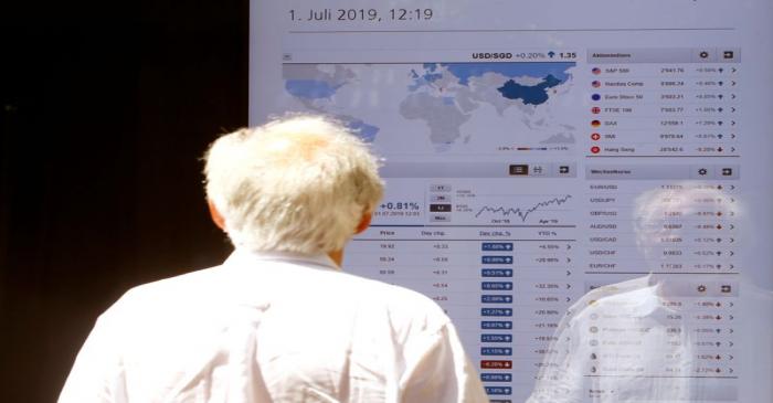 A man looks at a display showing the current stock prices at an office of Swiss bank UBS in