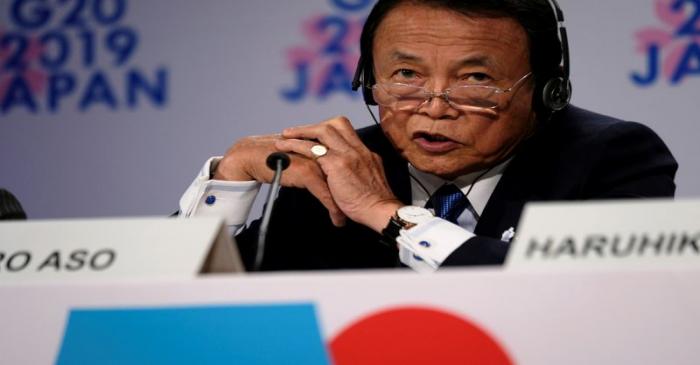 Japanese Finance Minister Taro Aso takes questions from reporters at the annual meetings of the