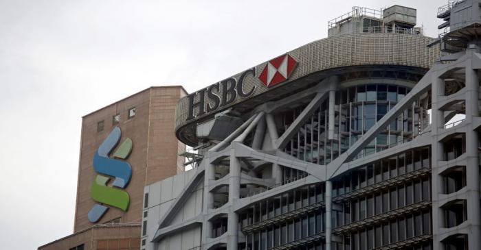 FILE PHOTO: Logos of HSBC and Standard Chartered banks are seen at their headquarters in Hong