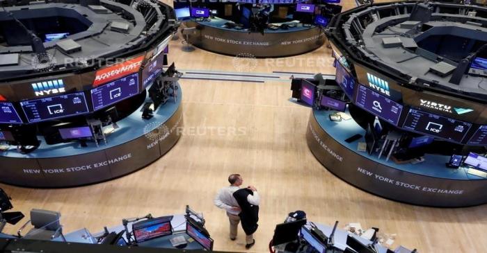 FILE PHOTO: A trader puts on his jacket on the floor of the New York Stock Exchange (NYSE) as