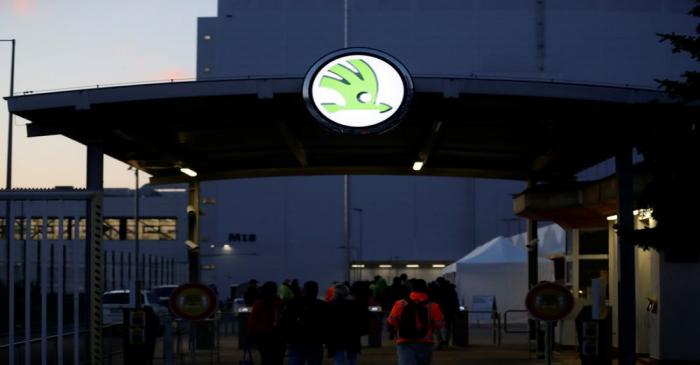 Workers enter Skoda Auto's factory as the company restarts production after shutting down last